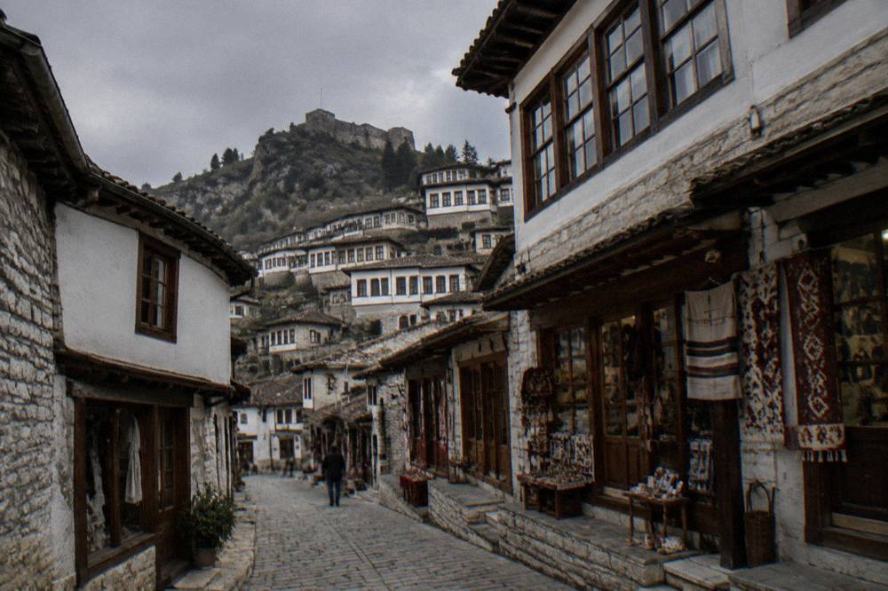Narrow stepped lane lined with small shopfronts in the Mangalem quarter of Berat
