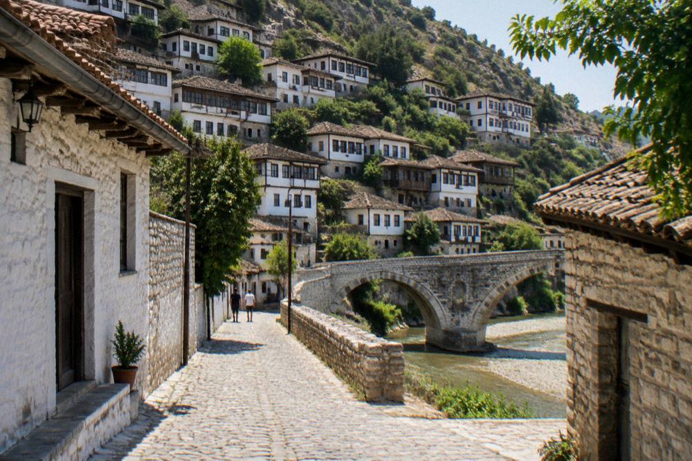 Cobblestone street in the Gorica quarter with old stone houses leading toward a stone bridge