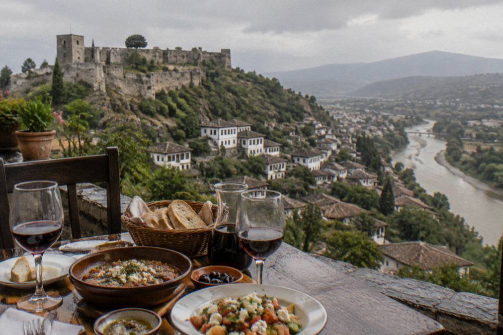 A table with local wine, bread and dishes at a guesthouse in Berat