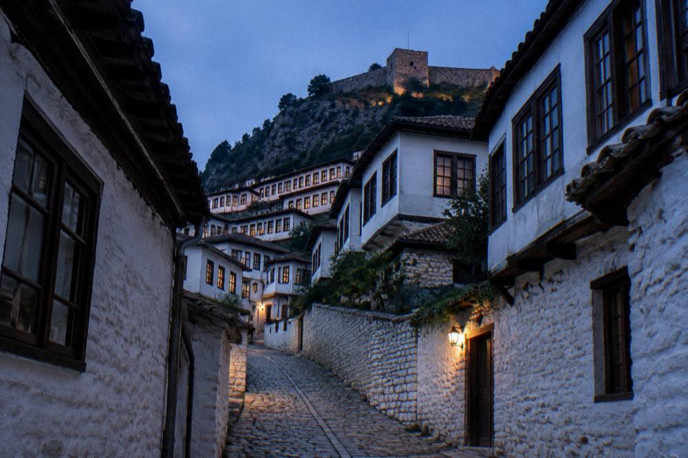 A narrow stone lane between whitewashed houses in Mangalem, Berat