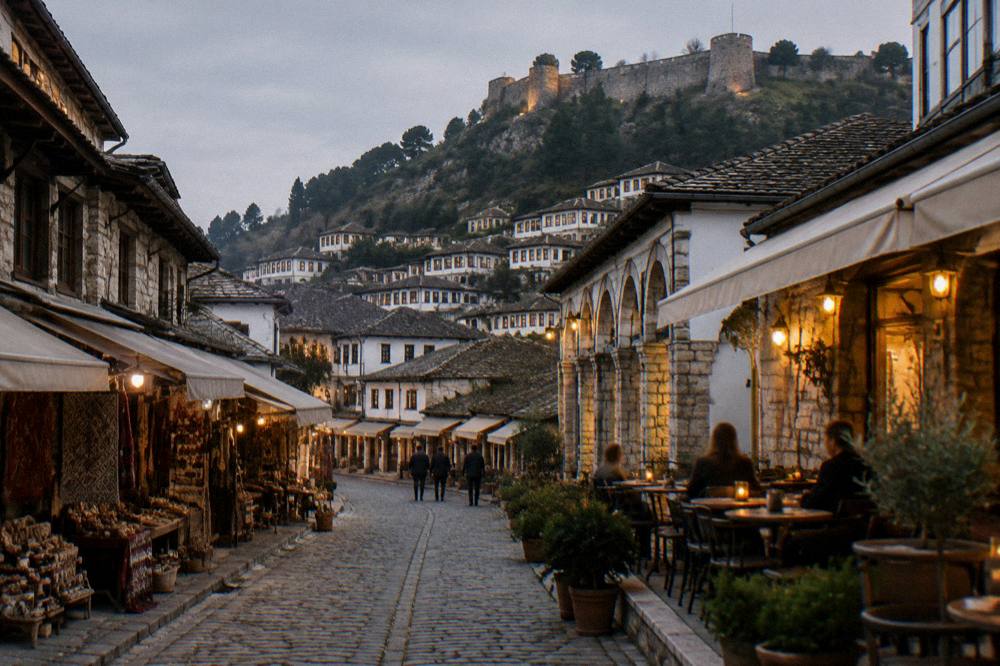 Evening cafe terrace with small tables and warm lights on a cobbled street
