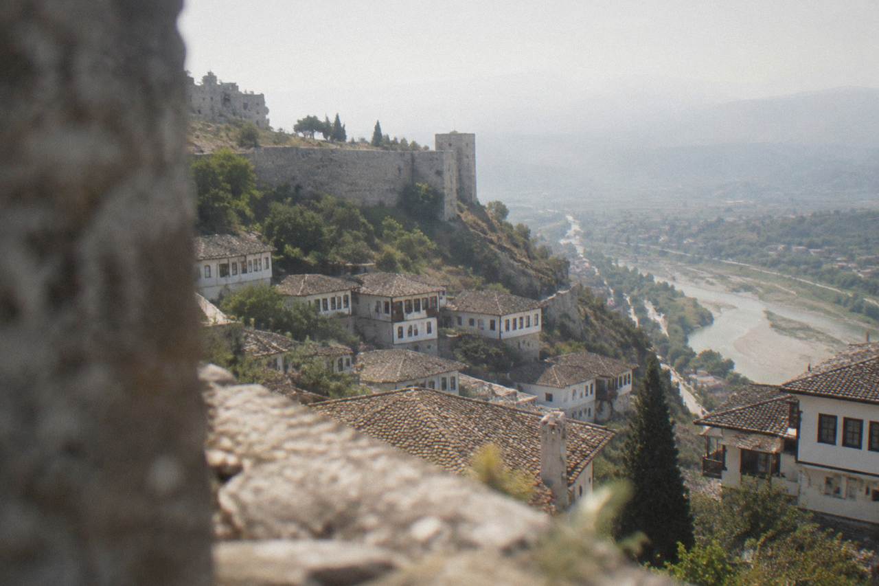 White Ottoman houses stacked on a hillside above the Osum River in Berat