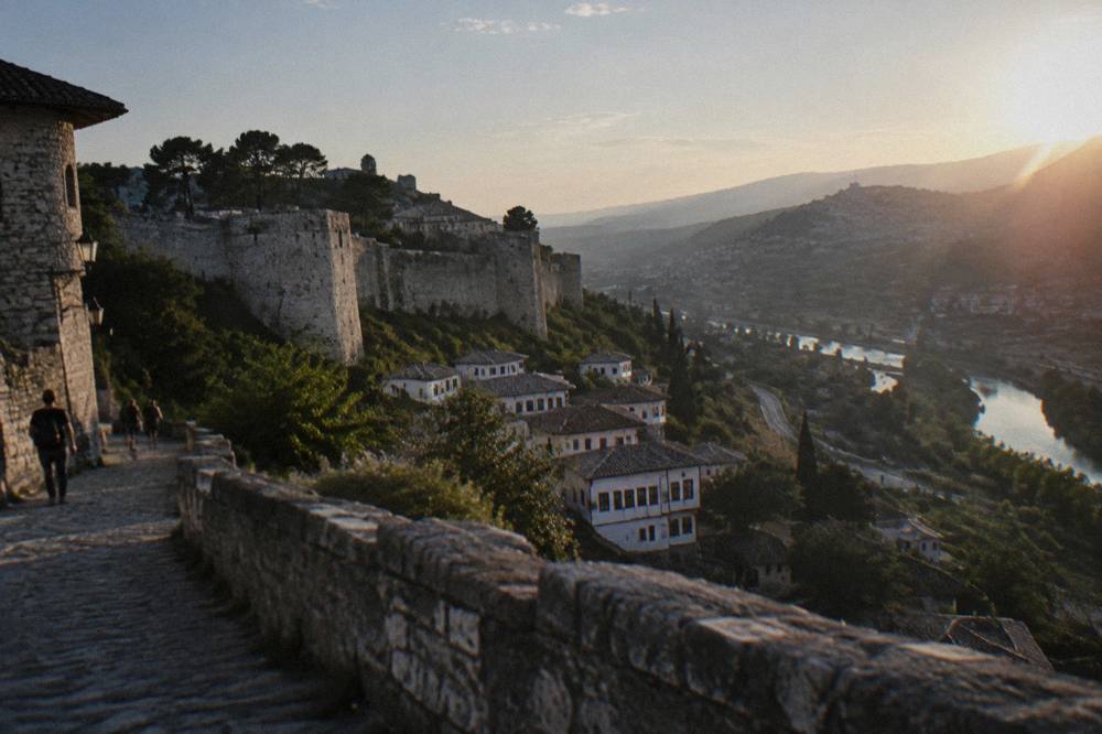 A winding road through hills toward a distant hilltop town in Albania