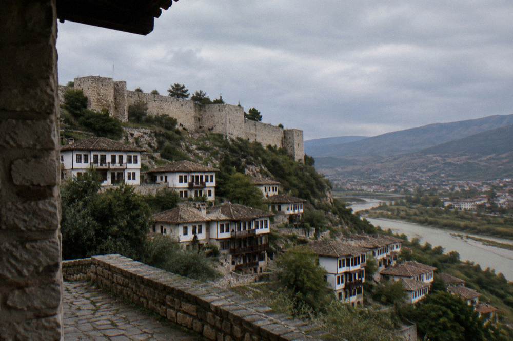 White Ottoman houses stacked on a hillside above the Osum River in Berat