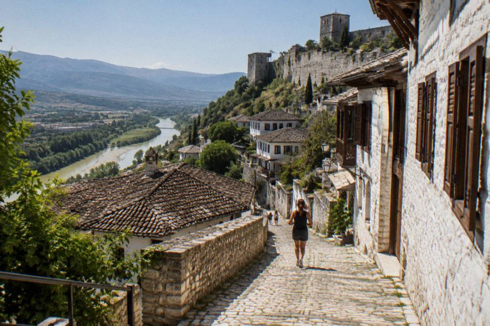 Narrow stone street lined with white houses and wooden shutters